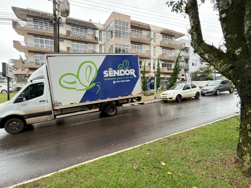 Caminhão baú com a identidade visual da Sêndor em rua de Chapecó/SC